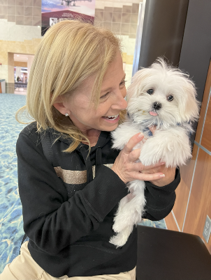 Happy new owner holding a Maltese puppy from Storybook Maltese