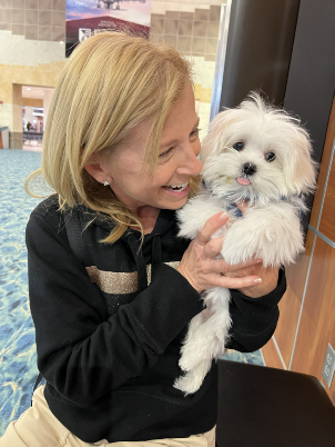 Happy new owner holding a Maltese puppy from Storybook Maltese