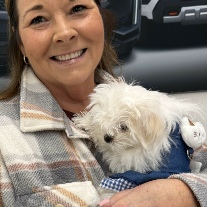 New Maltese puppy cuddled in owner’s arms on pickup day